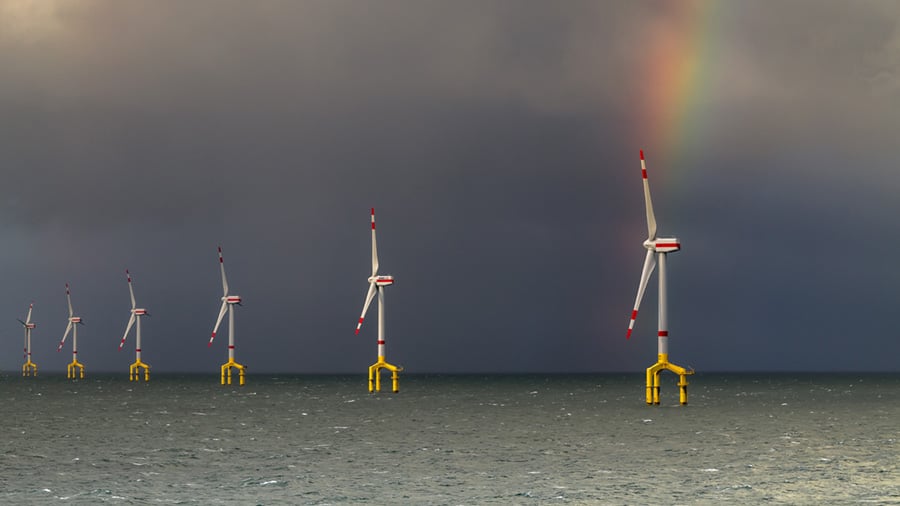 Six windmills spin above water and produce renewable energy.  Six windmills spin above water and produce renewable energy.